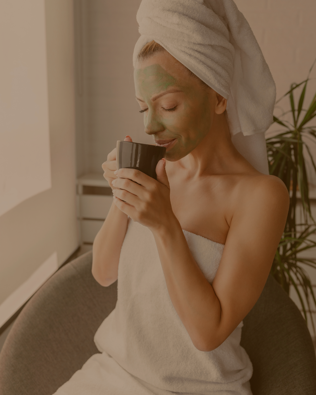 Donna con maschera viso e asciugamano beve tisana detox